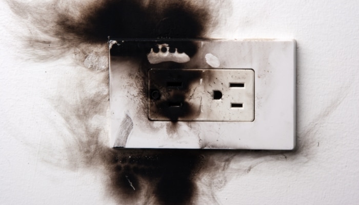 An electrical outlet blackened by electrical fire
